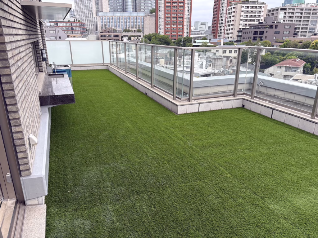 東京都港区のマンションのルーフバルコニーの人工芝施工事例(エターナルターフT35W・約100㎡・ローディーリフォーム様施工・都心スカイラインを望む高級レジデンス)